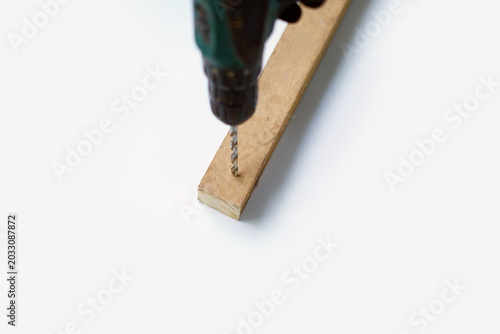 Drilling into wood piece on white background. image