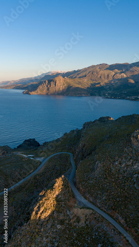 Winding road on the Crete coastline through the mountains at sunrise