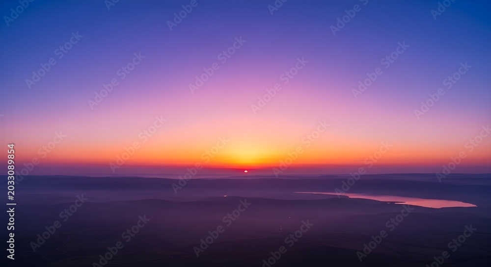 Fototapeta premium Breathtaking sunrise over the sea of galilee in israel, featuring a vibrant purple and orange sky with misty hills and calm water in the distance
