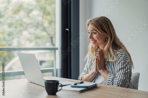 Konstfotografi Smiling young woman happily looking at laptop screen, participating in an online