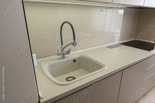 Tableau sur toile beige kitchen countertop features an integrated sink with a flexible gooseneck f