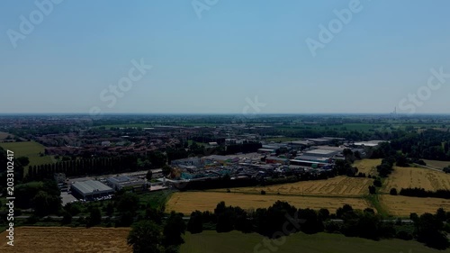 Aerial View of Industrial Park and Farmland: An expansive drone view showcases a modern industrial park nestled amidst rolling farmland under a clear blue sky.