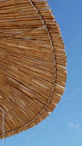 Tropical bamboo parasol against blue sky, beach holiday atmosphere, sunny coastal travel lifestyle
