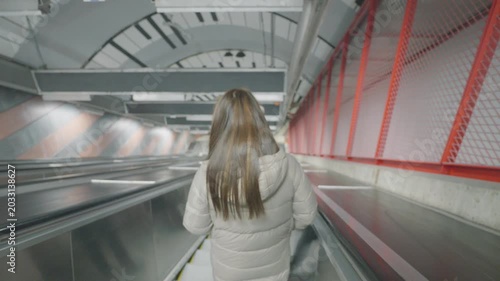 A person walking through a sleek, contemporary subway station. The design features modern architecture with clean lines and vibrant colors. The scene captures the essence of urban commuting.
