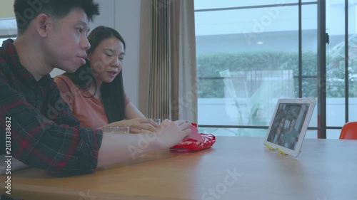 A candid capture of two individuals enjoying a video call at home, sharing laughter and connection in a cozy setting.