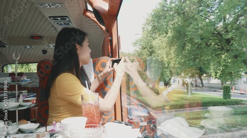 A woman enjoys a delightful meal while seated in a stylish train interior, surrounded by greenery outside. The relaxed atmosphere enhances the enjoyment of dining on the move.