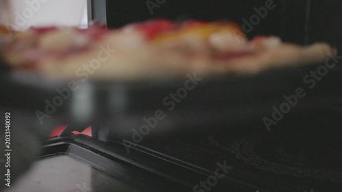 A hand holds a tray of freshly baked pastries, showcasing their golden crust and colorful toppings. This delightful scene highlights the joy of home baking and the tempting treats awaiting enjoyment.