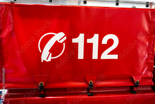 Quadro su tela Emergency Number 112 on Firefighter Vehicle Cover, Close up photograph of emergency number 112 displayed on a red protective cover mounted on a firefighter or rescue vehicle