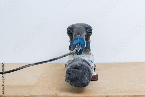 фотографія Orbital sander standing on wooden board