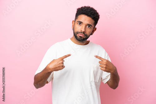 Tableau sur toile Young Brazilian man isolated on pink background pointing to oneself