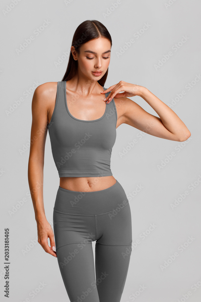Obraz premium Athletic girl on the gray background. Fitness woman
