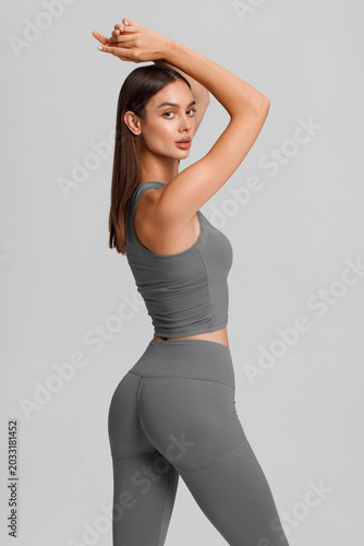 Athletic girl on the gray background. Fitness woman