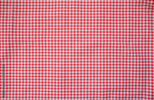 Red and white check table cloth background. Top view. Copy space. Summer outdoor food or picnic theme.