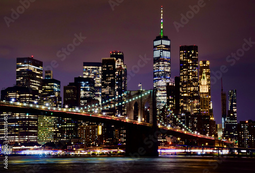 Tableau sur toile Brooklyn Bridge illuminated at night with glowing Lower Manhattan skyline and On