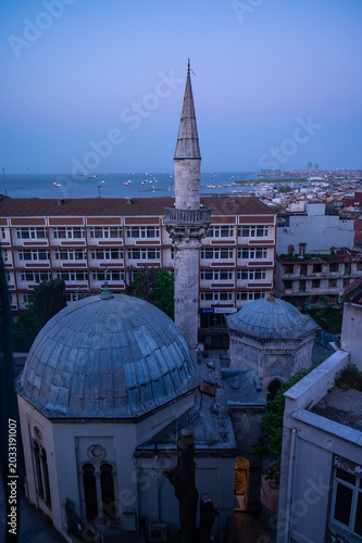 a mosque with the panoramic view of the city and the sea