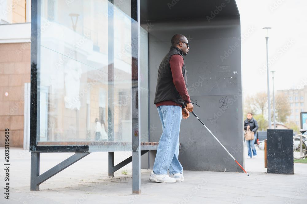Fototapeta premium African american man waiting at bus stop with cane