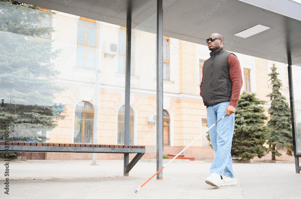 Fototapeta premium African american man navigating city street with cane