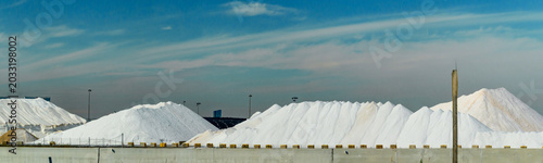 The large white mounds are likely stockpiles of rock salt, commonly stored at shipping terminals to be distributed for winter road maintenance.