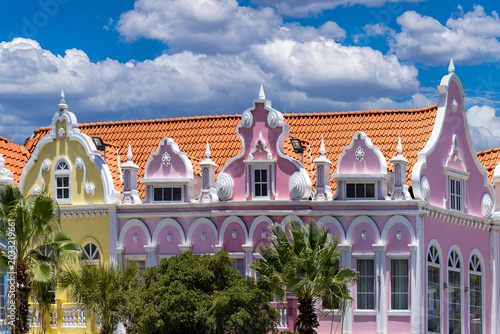 A wide panoramic shot of colorful pink yellow and blue Dutch colonial style architectural facades in downtown Oranjestad Aruba Caribbean vacation destination