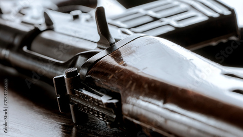 Close-up shows rifle with wooden stock and black metal parts