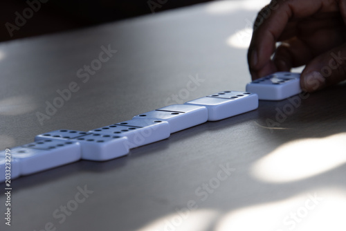 Hand moving domino tile during game play