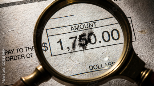 Forged Bank Check with Altered Numbers - Document Forgery Investigation and Financial Fraud Evidence under Magnification
