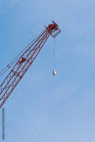 Foto Red construction crane boom lattice jib against clear blue sky