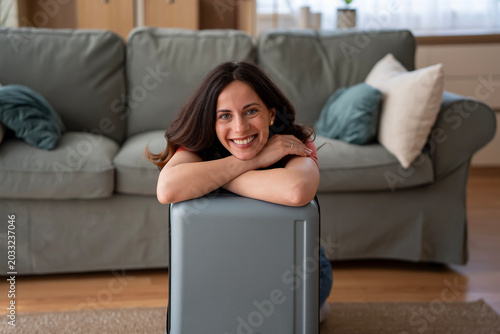 Photos Woman smiling leaning on suitcase preparing for travel