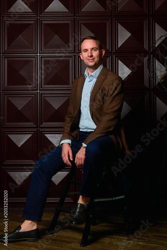a man in a three-piece suit against a dark wall