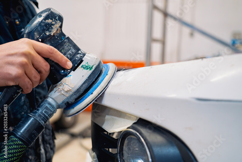 Принти на полотні Primer plano de preparador de pintura lijando paragolpes de coche blanco con lij