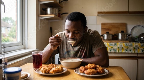 Man eating fried chicken breakfast at kitchen table