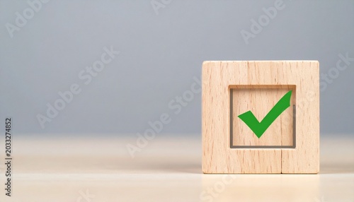 Wooden cube with green check mark on a light surface and gray background, symbolizing success, approval, and reliability.