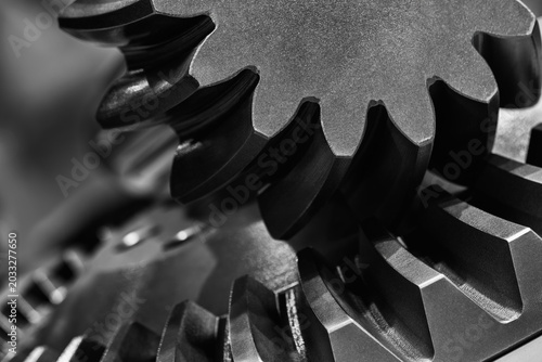 Close-up of metal gears. Black and white photography. Smooth, precise surfaces. Interlocking mechanical parts. Industrial equipment components. Industrial background.