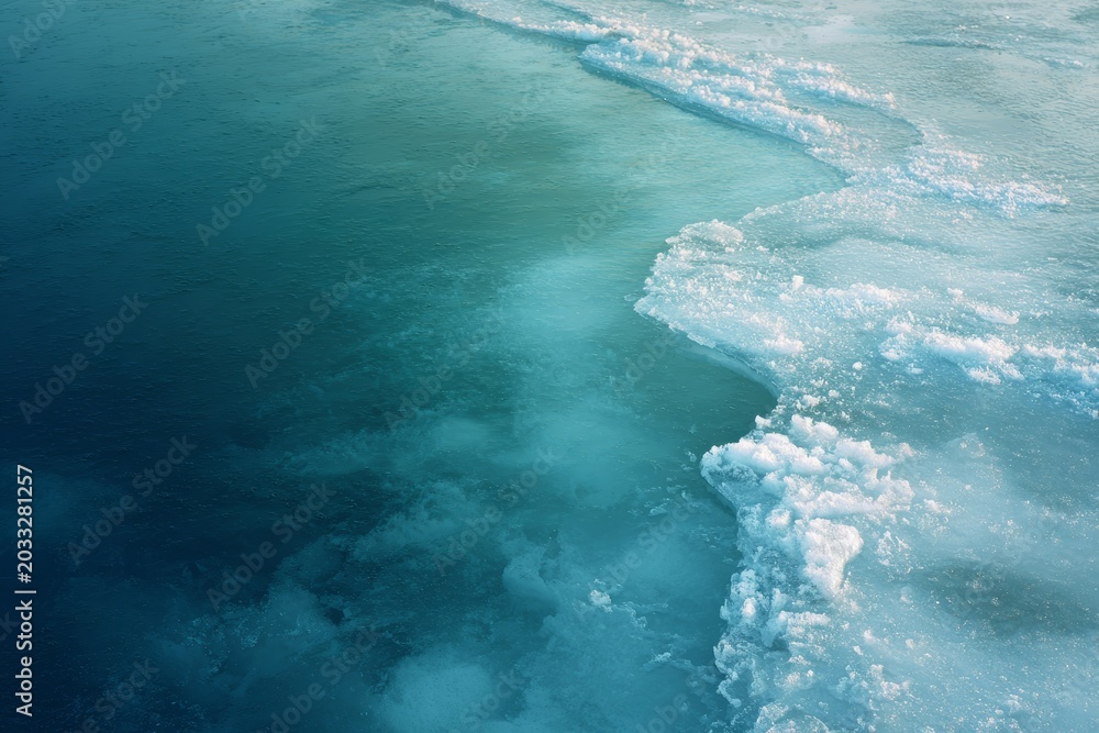 Obraz premium Frozen ocean surface with cracked ice and deep blue water