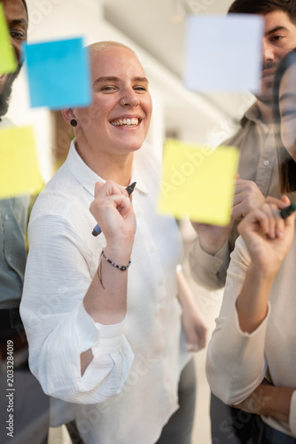 Diverse business team brainstorming ideas on glass wall