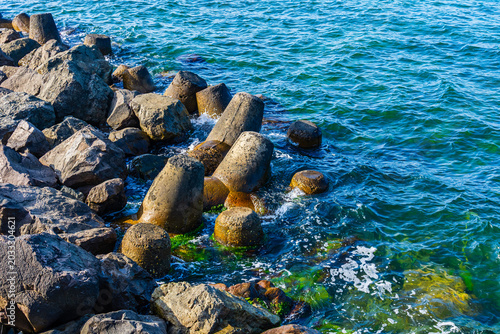 Concrete tetrapods in sea. Coastal defence barrier