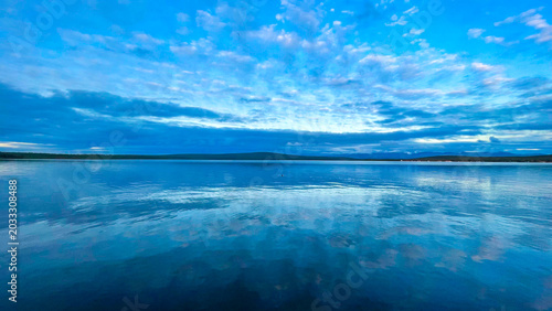 Foto Mirror-Like Water Reflections Under Blue Cloudy Sky – Minimalist Coastal Seascap