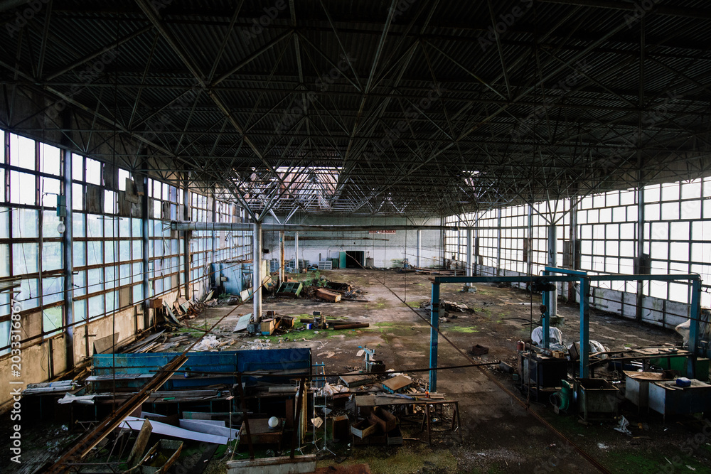 Fototapeta premium Old ruined factory building overgrown by green moss and plants