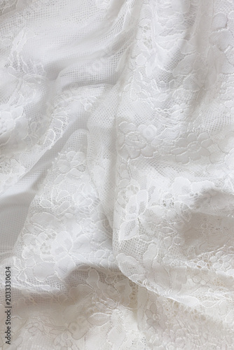Fotografija White floral lace fabric with elegant folds and texture