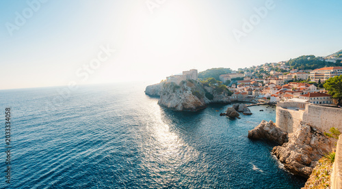 Foto Dubrovnik's historic fortifications and old port at dusk, featuring sunlight on