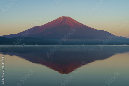 Bild auf Leinwand Stunning Aka-Fuji (Red Mount Fuji) with a perfect reflection on the mirror-like surface of Lake Yamanaka in September, Japan