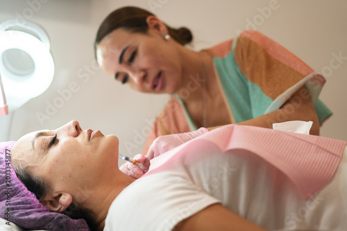 Fotografija Woman receiving cosmetic injection for skin rejuvenation in clinic