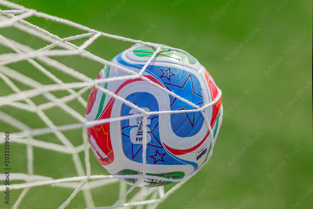 Naklejka premium Calgary, AB, Canada. May 23, 2026. Official FIFA World Cup 2026 match ball hitting the white goal net on a sunny green pitch.
