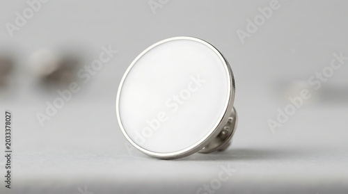 Isolated circular white enamel pin badge with metallic silver edge for custom branding and corporate merchandise display