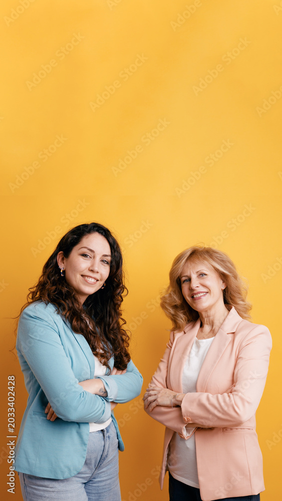 Fototapeta premium Professional women with crossed arms standing confidently, representing mentorship, corporate success, and diverse experience