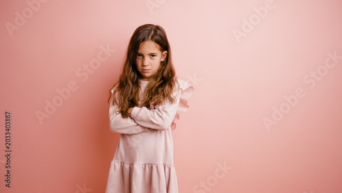 Bild auf Leinwand Young girl stands with arms crossed, expressing anger and frustration