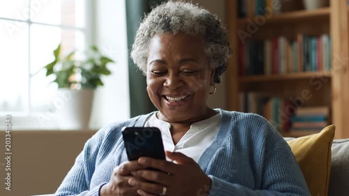 Senior woman smiles with phone.