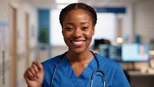 Smiling nurse in hospital corridor.