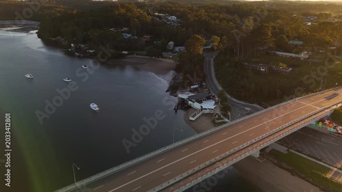 Aerial drone reverse view of Batemans Bay on the NSW South Coast, Australia, looking over Clyde River Bridge rotating to view the CBD on a sunny early morning in May 2026   