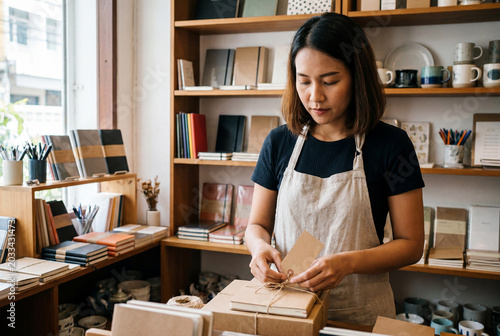 Small Business Owner Wrapping a Notebook in a Stationery Shop